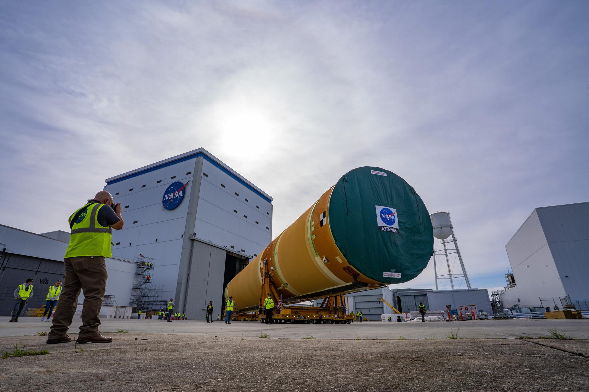 NASA moved the core stage, or the largest section, of the SLS (Space Launch System) rocket that will launch the crewed Artemis III mission in 2027 from the agency’s Michoud Assembly Facility to the agency’s Pegasus barge in New Orleans on April 20. The barge will ferry the top four-fifths – the section containing the liquid hydrogen tank, liquid oxygen tank, intertank, and forward skirt – of the SLS core stage to NASA’s Kennedy Space Center in Florida to complete outfitting and vertical integration.  Teams with NASA and Boeing, the SLS core stage lead contractor, used specialized transporters to guide the top four-fifths from the NASA rocket factory to Pegasus. Prior to the move, technicians added an engine section transportation simulator to the rocket stage for shipment to the Space Coast.  Next year’s Artemis III mission will launch astronauts to Earth’s orbit aboard the Orion spacecraft on top of SLS to test rendezvous and docking capabilities between Orion and commercial spacecraft needed to land Artemis IV astronauts on the Moon in 2028. NASA’s SLS is the only rocket capable of sending Orion, astronauts, and supplies to the Moon in a single launch.