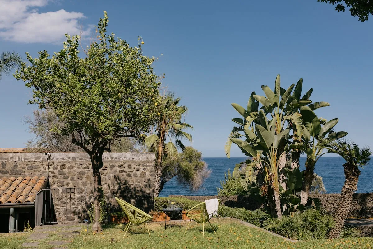 Image may contain Nature Outdoors Scenery Summer Chair Furniture Sea Water Grass Plant Vegetation and Beach