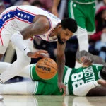 Philadelphia 76ers' Paul George, left, chases a loose ball past the Boston Celtics' Neemias Queta
