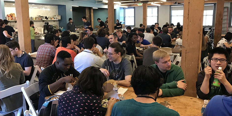 Groups of people sitting around tables in a crowded room