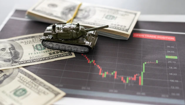 a toy tank, dollars and a tablet