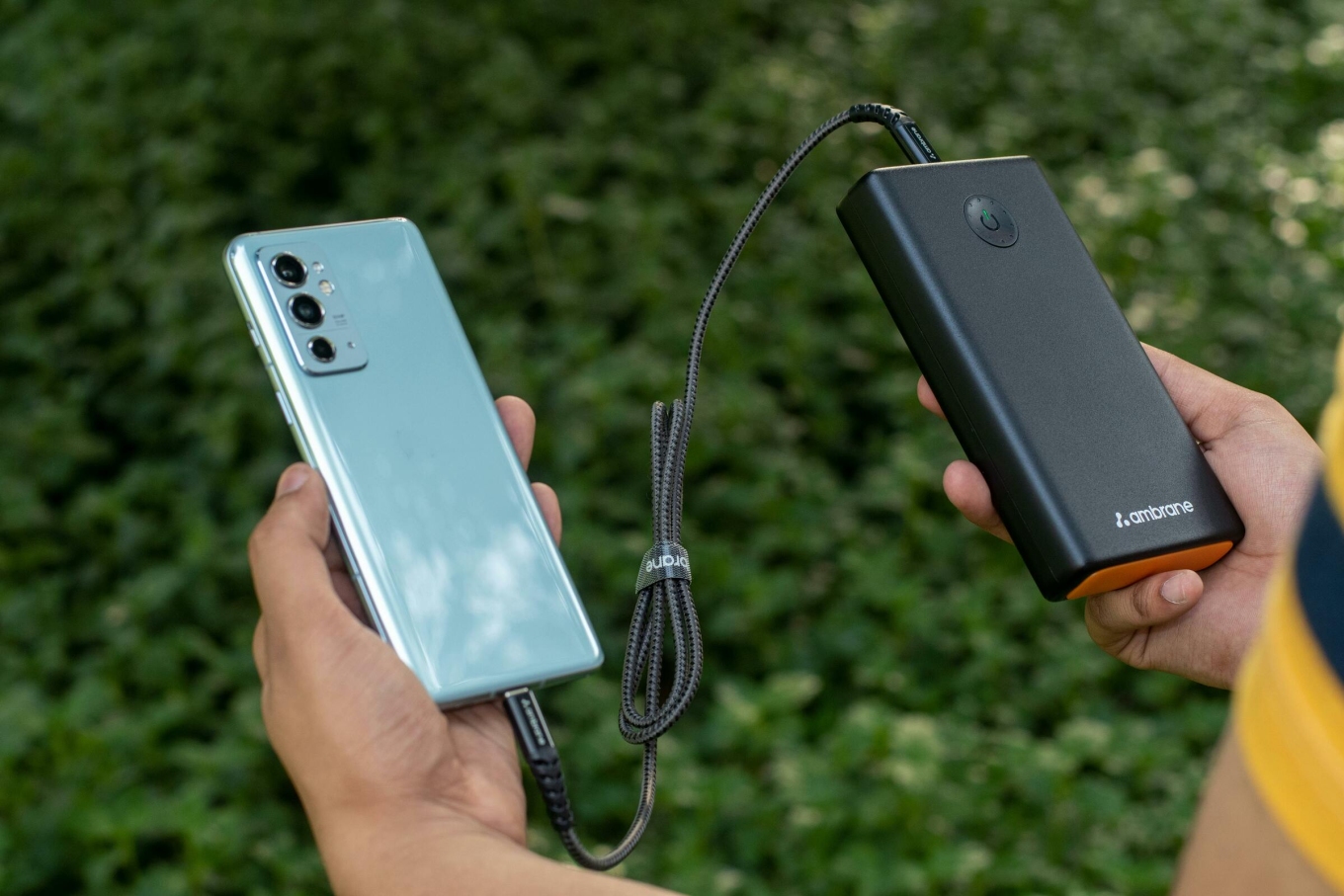 A smartphone charges using a portable power bank.