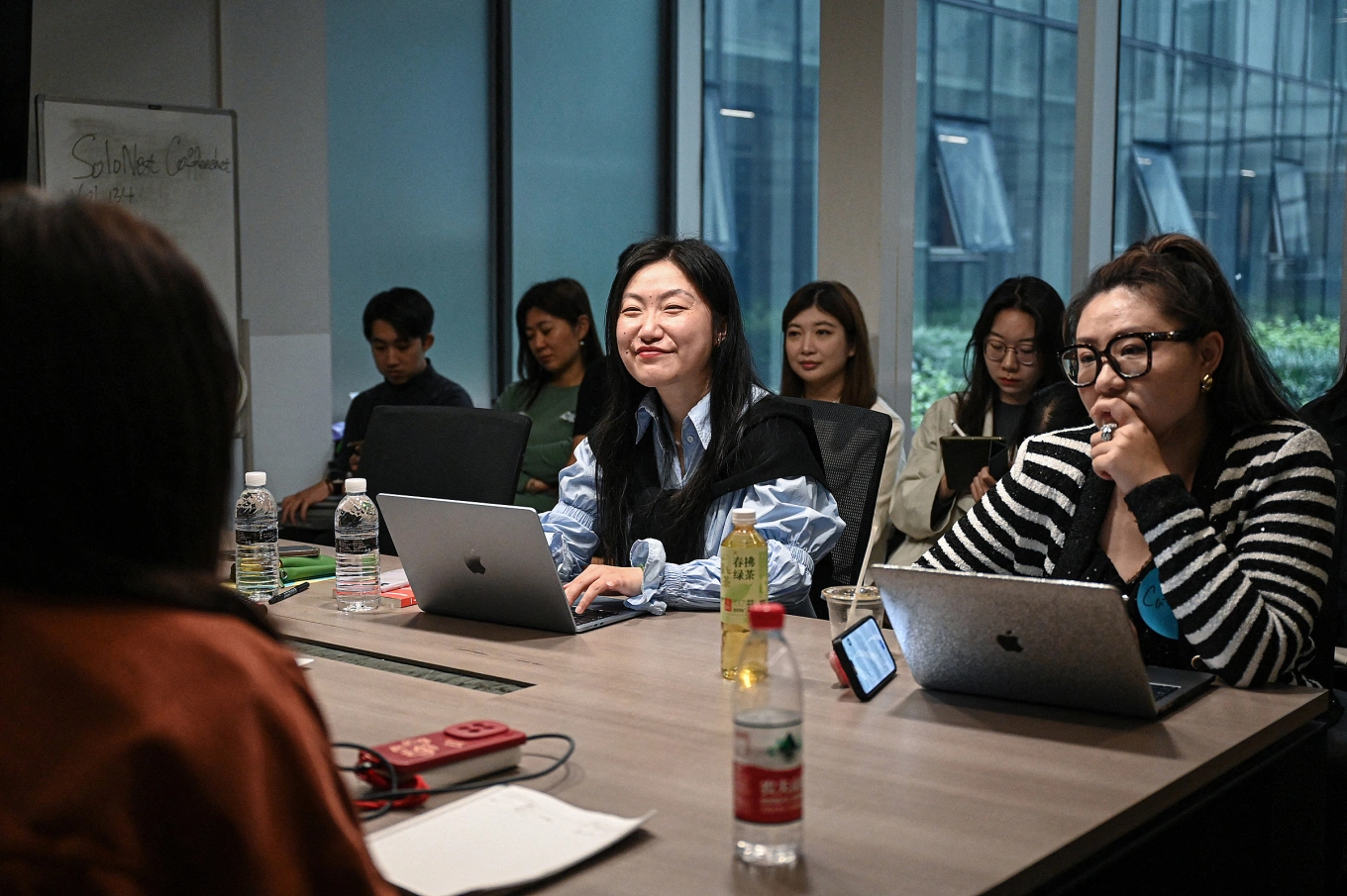 The photo taken on April 12, 2026 shows Karen Dai (C), founder of one-person company SoloNest, sharing her experience with participants during a coffee chat at a conference room in Shanghai. Photo by AFP