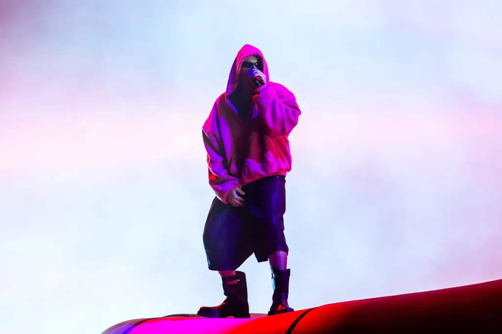 Image may contain Purple Performer Person Solo Performance Clothing Coat Adult Photography Face Head and Portrait