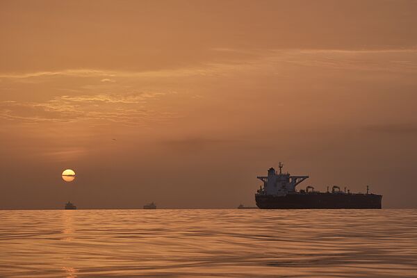 El sol se levanta detrás de varios buques petroleros anclados en el estrecho de Ormuz, frente a la costa de la isla Qeshm, Irán