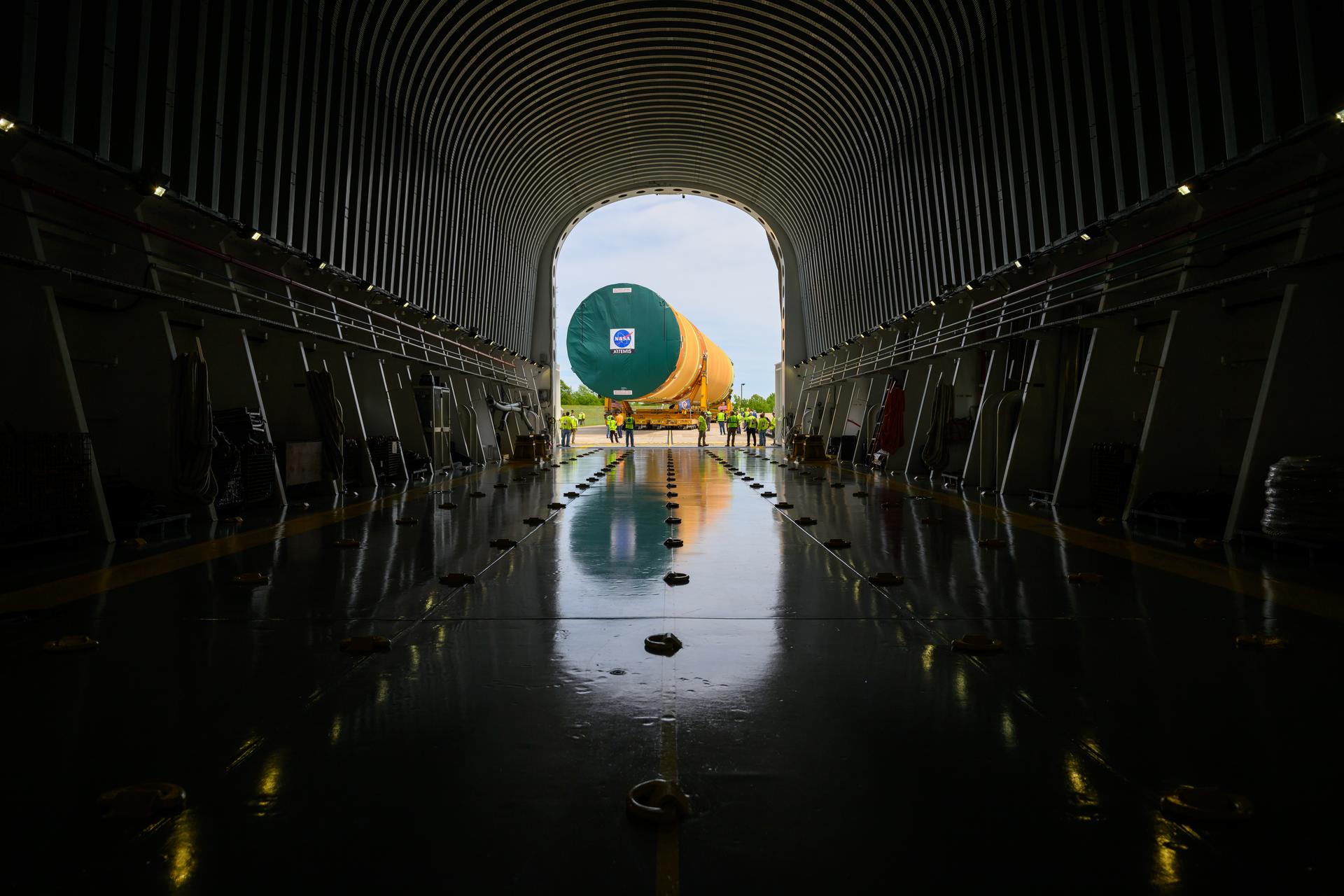 NASA moved the core stage, or the largest section, of the SLS (Space Launch System) rocket that will launch the crewed Artemis III mission in 2027 from the agency’s Michoud Assembly Facility to the agency’s Pegasus barge in New Orleans on April 20. The barge will ferry the top four-fifths – the section containing the liquid hydrogen tank, liquid oxygen tank, intertank, and forward skirt – of the SLS core stage to NASA’s Kennedy Space Center in Florida to complete outfitting and vertical integration.  Teams with NASA and Boeing, the SLS core stage lead contractor, used specialized transporters to guide the top four-fifths from the NASA rocket factory to Pegasus. Prior to the move, technicians added an engine section transportation simulator to the rocket stage for shipment to the Space Coast.  Next year’s Artemis III mission will launch astronauts to Earth’s orbit aboard the Orion spacecraft on top of SLS to test rendezvous and docking capabilities between Orion and commercial spacecraft needed to land Artemis IV astronauts on the Moon in 2028. NASA’s SLS is the only rocket capable of sending Orion, astronauts, and supplies to the Moon in a single launch. 
