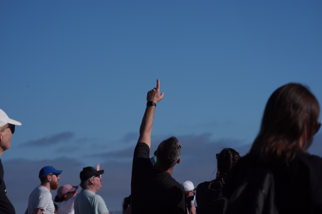 People look on during a watch party for the return of the Artemis II crew in the Orion capsule in Coronado, California, on Friday.