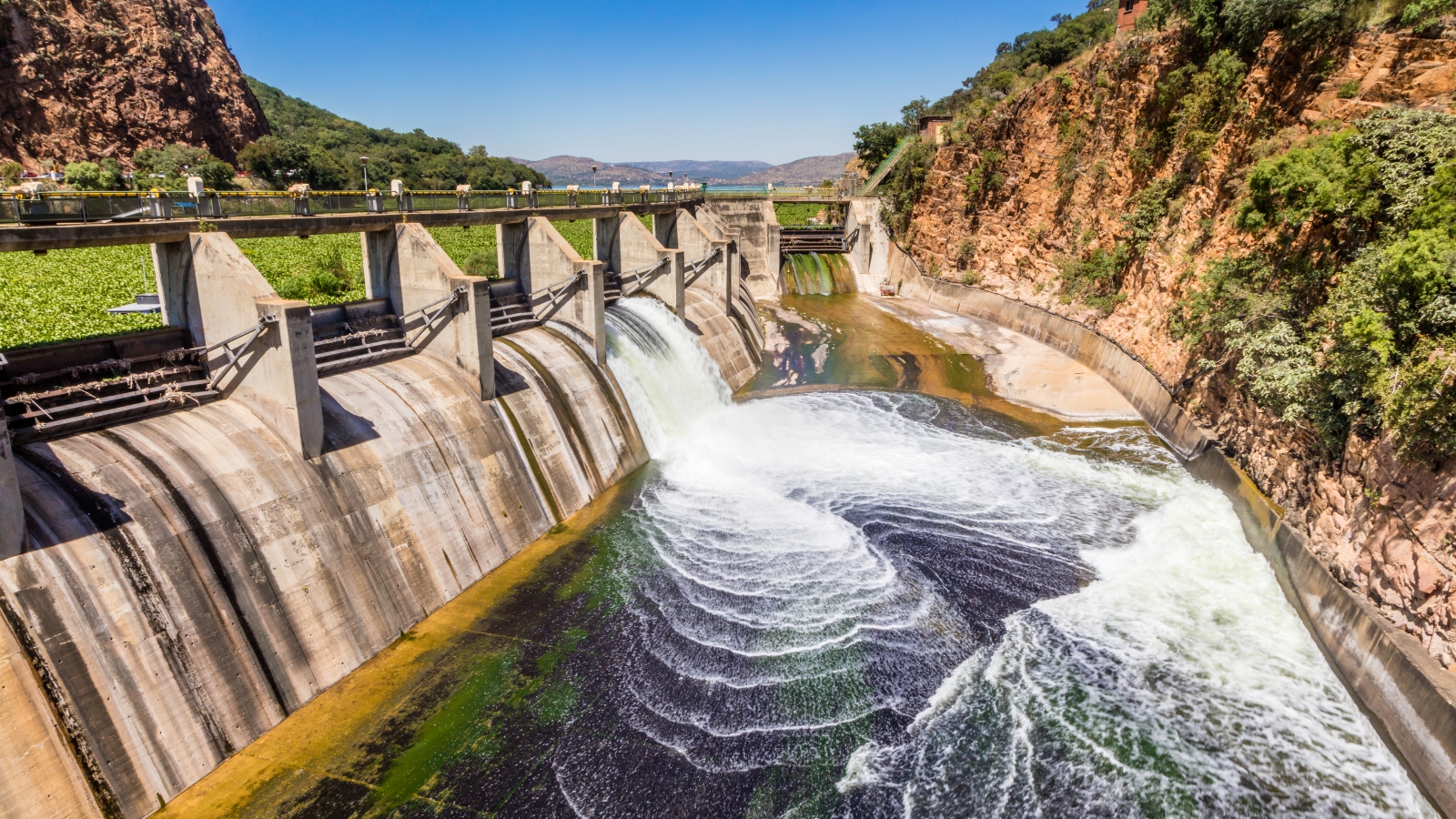 A photo of water rushing through a gate in in the Hartebeespoort Dam