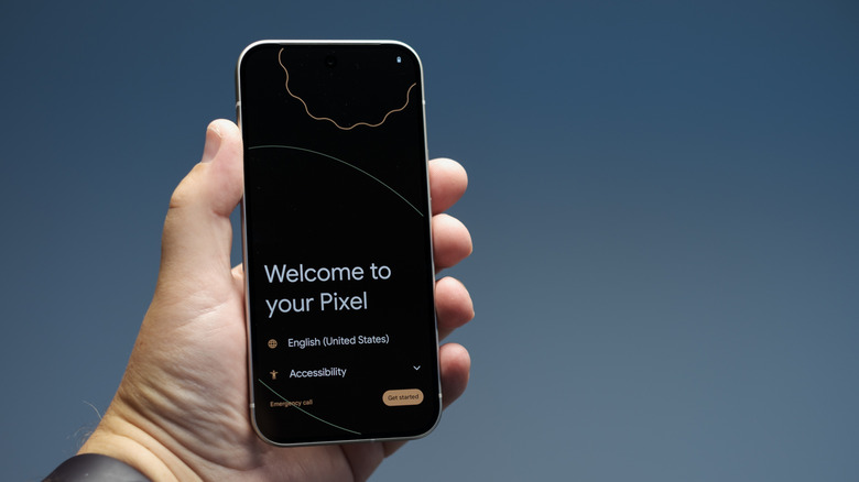 Close-up of a person holding the Pixel 9 with its setup guide on the display