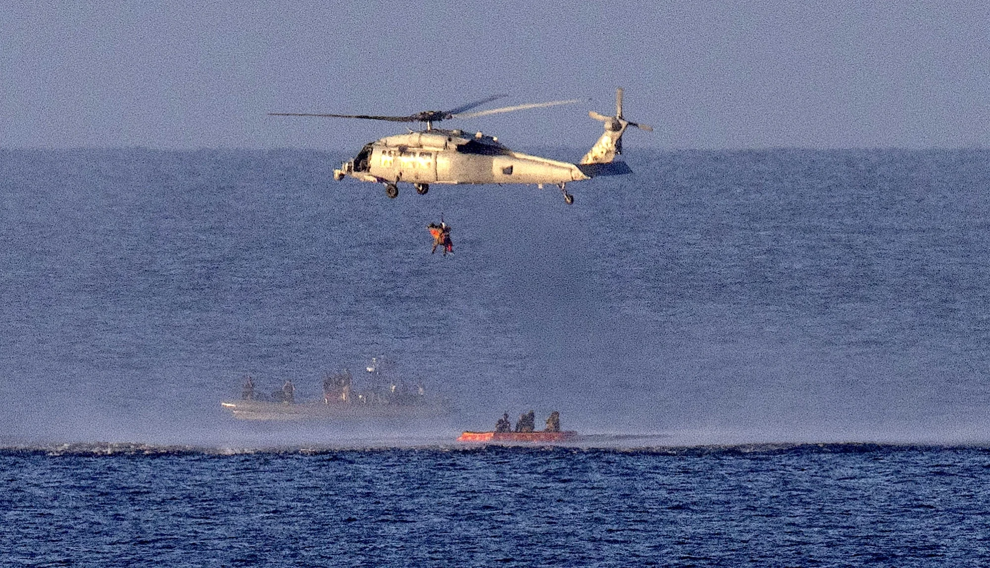 A helicopter lifts NASA astronaut Reid Wiseman, Artemis II commander, out of the pacific