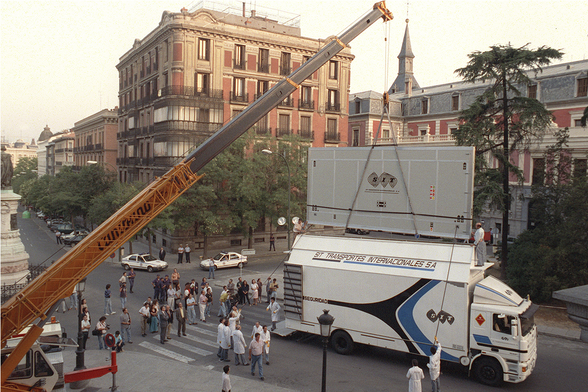 La gr�a levanta la mercanc�a y carga el cami�n por el techo, con ayuda de dos operarios, mediante dos cintas sujetas a la caja que consiguen la verticalidad constante, sin giros.