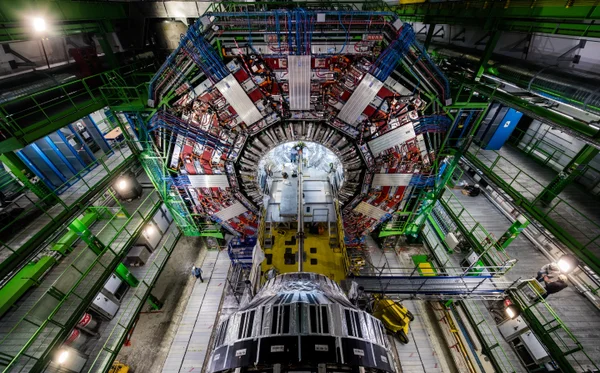 A photograph shows the large detector face of the The Compact Muon Solenoid (CMS) experiment at the Large Hadron Collider