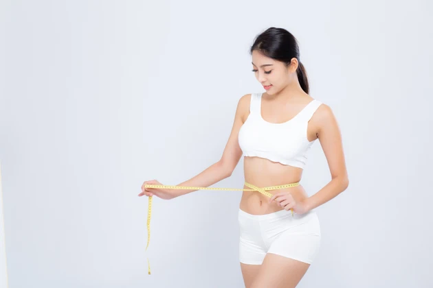 beautiful portrait asian woman diet and slim with measuring waist for weight isolated on white background, girl have cellulite and calories loss with tape measure, health and wellness concept.