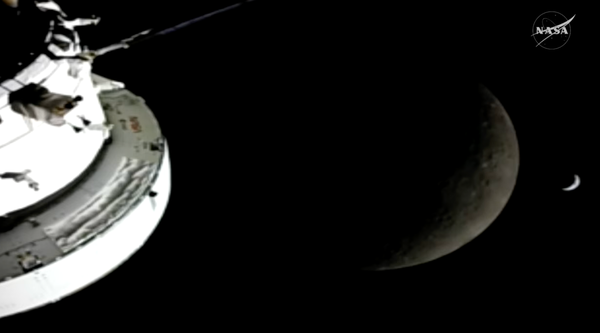 A grainy view of a spacecraft, the crescent moon and the crescent Earth.