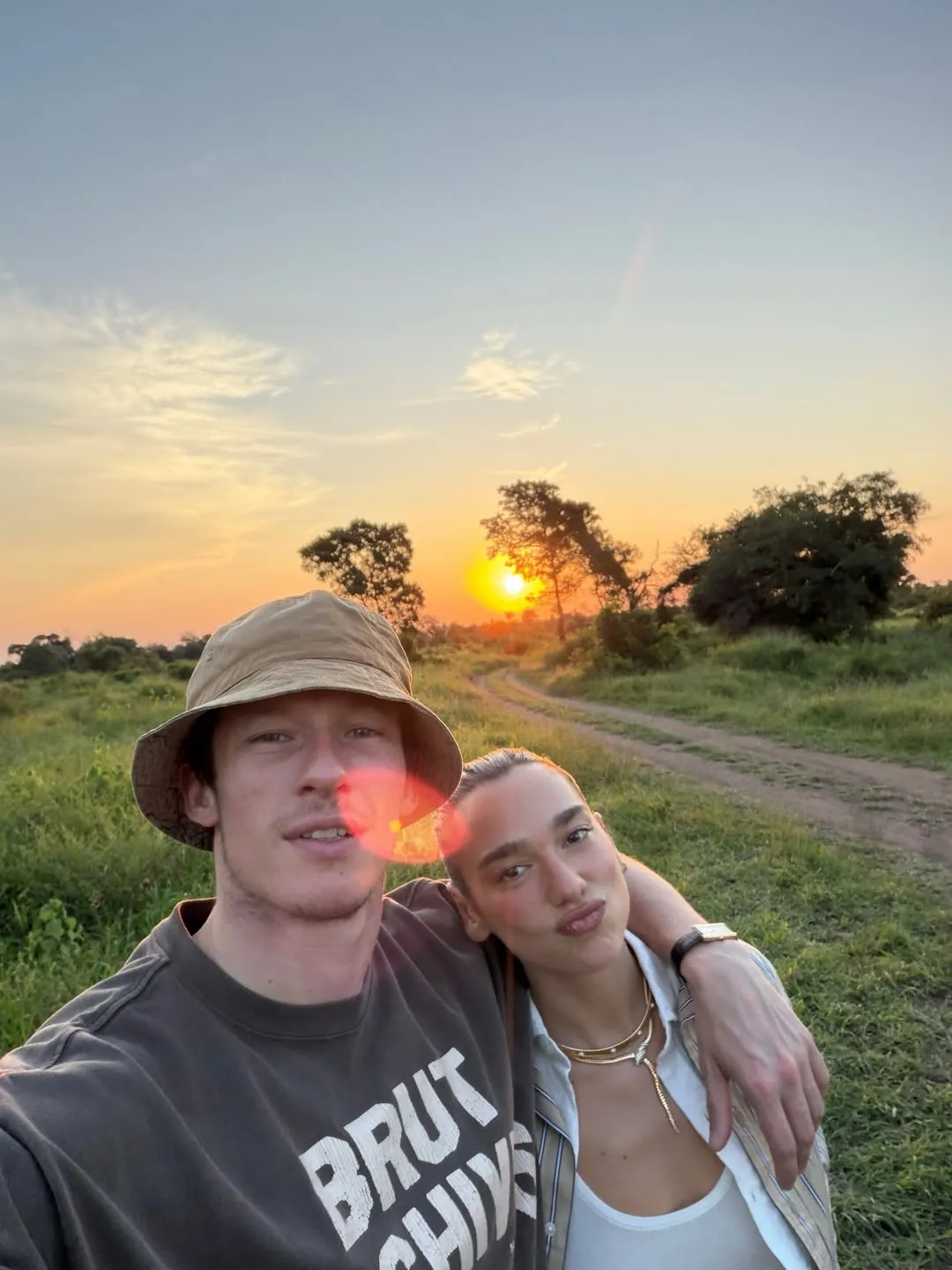 Image may contain Callum Turner Dua Lipa Nature Outdoors Sky Sun Face Head Person Photography Portrait and Grass