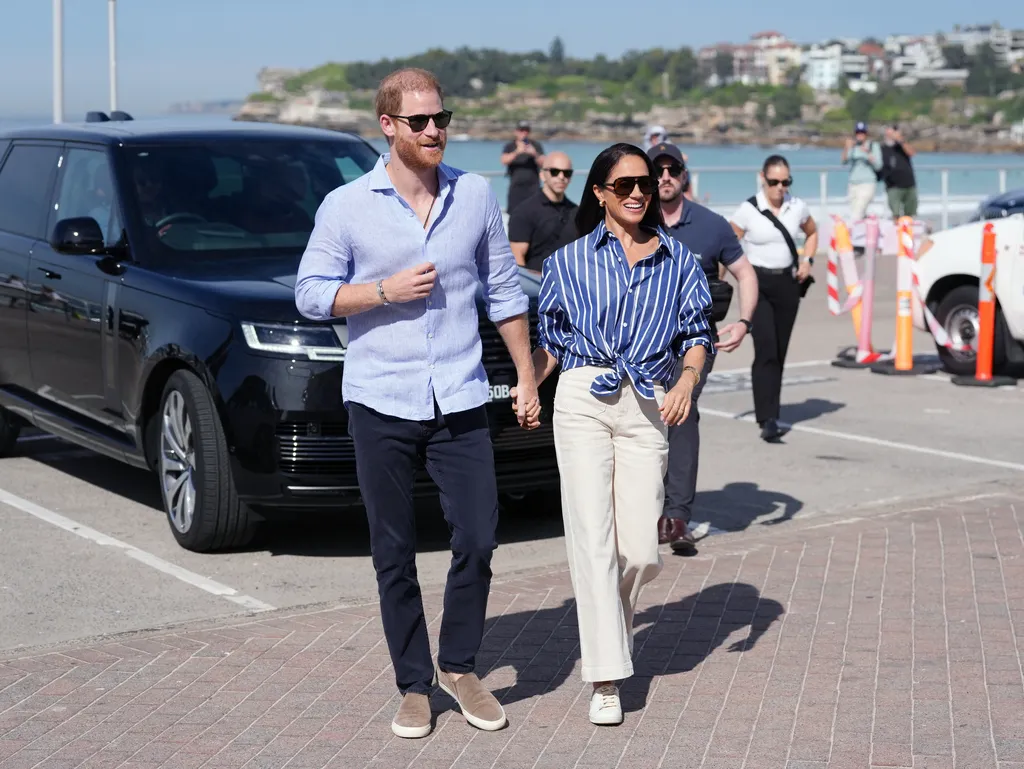 Britain's Prince Harry Duke of Sussex and his wife Meghan the Duchess of Sussex arrive to meet with volunteer first...