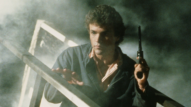 Eric Cord in fog while holding a revolver.