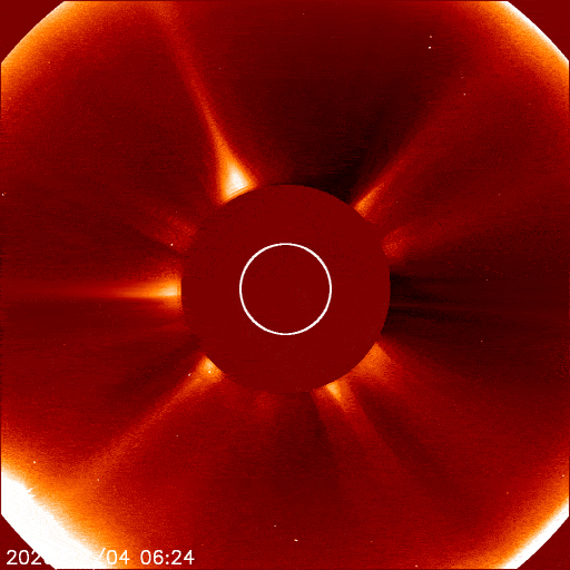 Looped video footage of a comet shooting toward the sun and a cloud f debris coming out the other side of the obscured solar disk