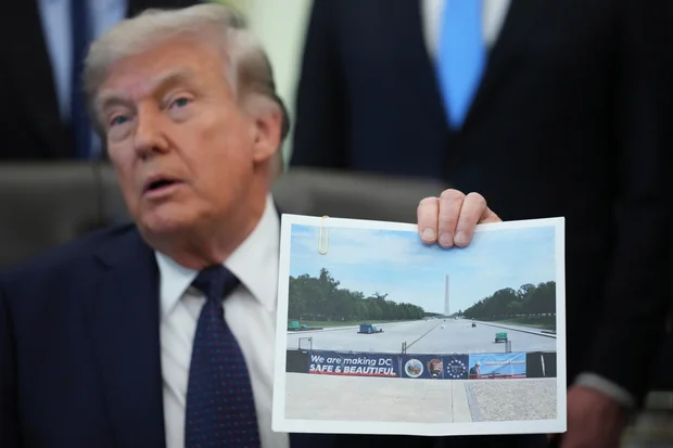 President Trump holds an image of the Lincoln Memorial Reflecting Pool during an event on health care affordability in the Oval Office at the White House, Thursday, April 23, 2026, in Washington. 