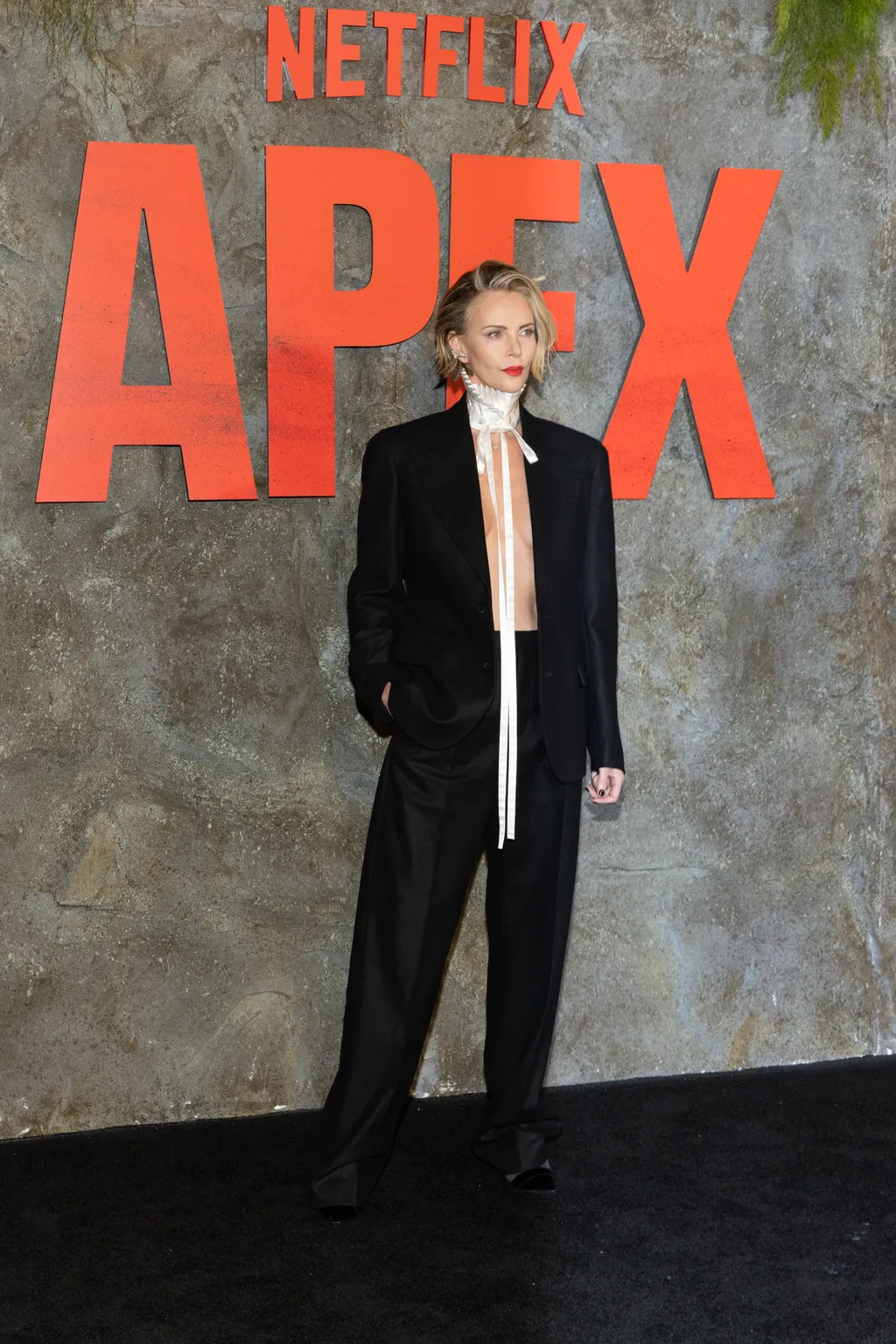 Image may contain Charlize Theron Clothing Formal Wear Suit Coat Blazer Jacket Publication Accessories and Tie