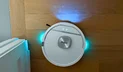 Shark PowerDetect UV Reveal 2-in-1 robot vacuum illuminating dried stain on hardwood floor