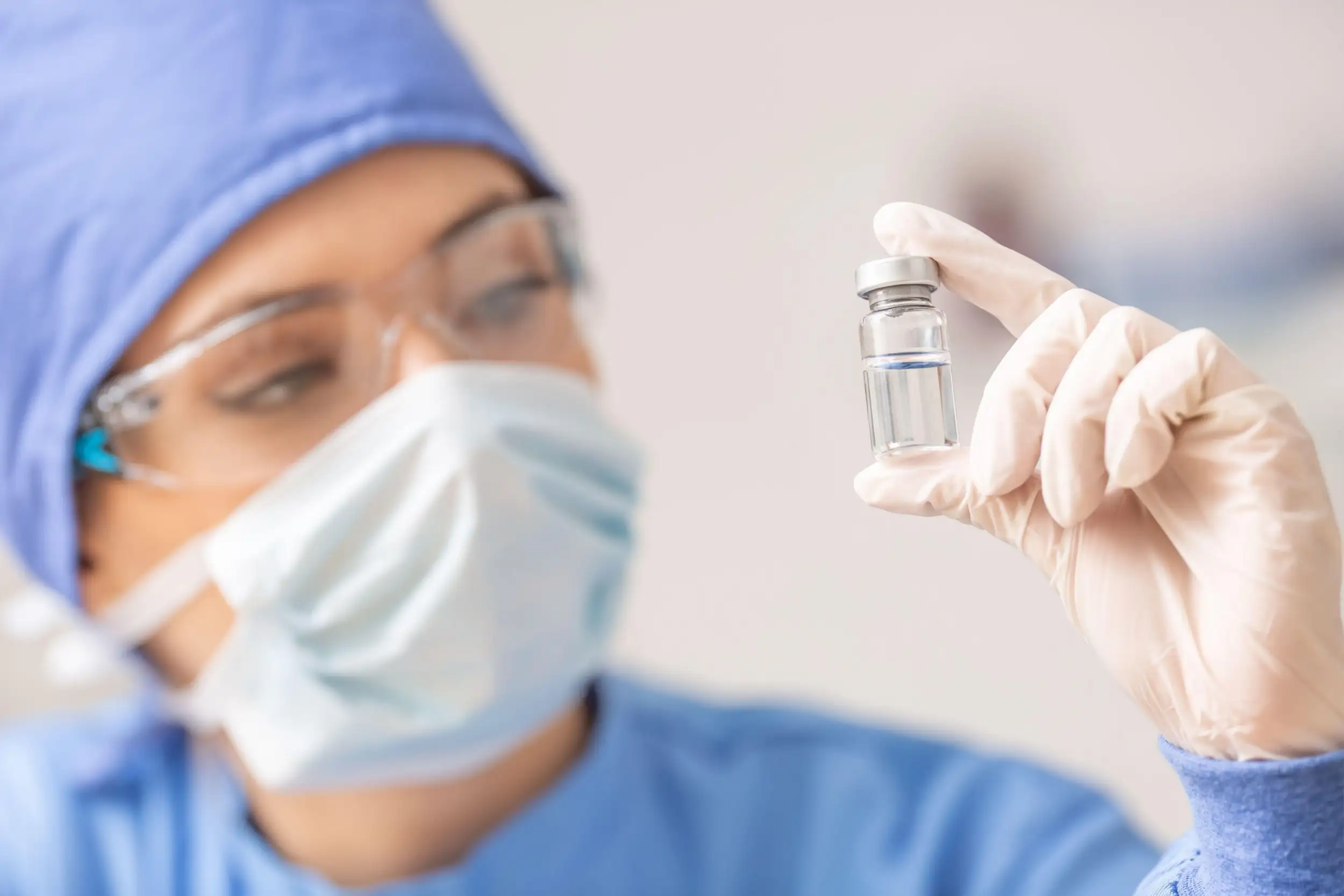 woman holding ampoule of virus vaccine
