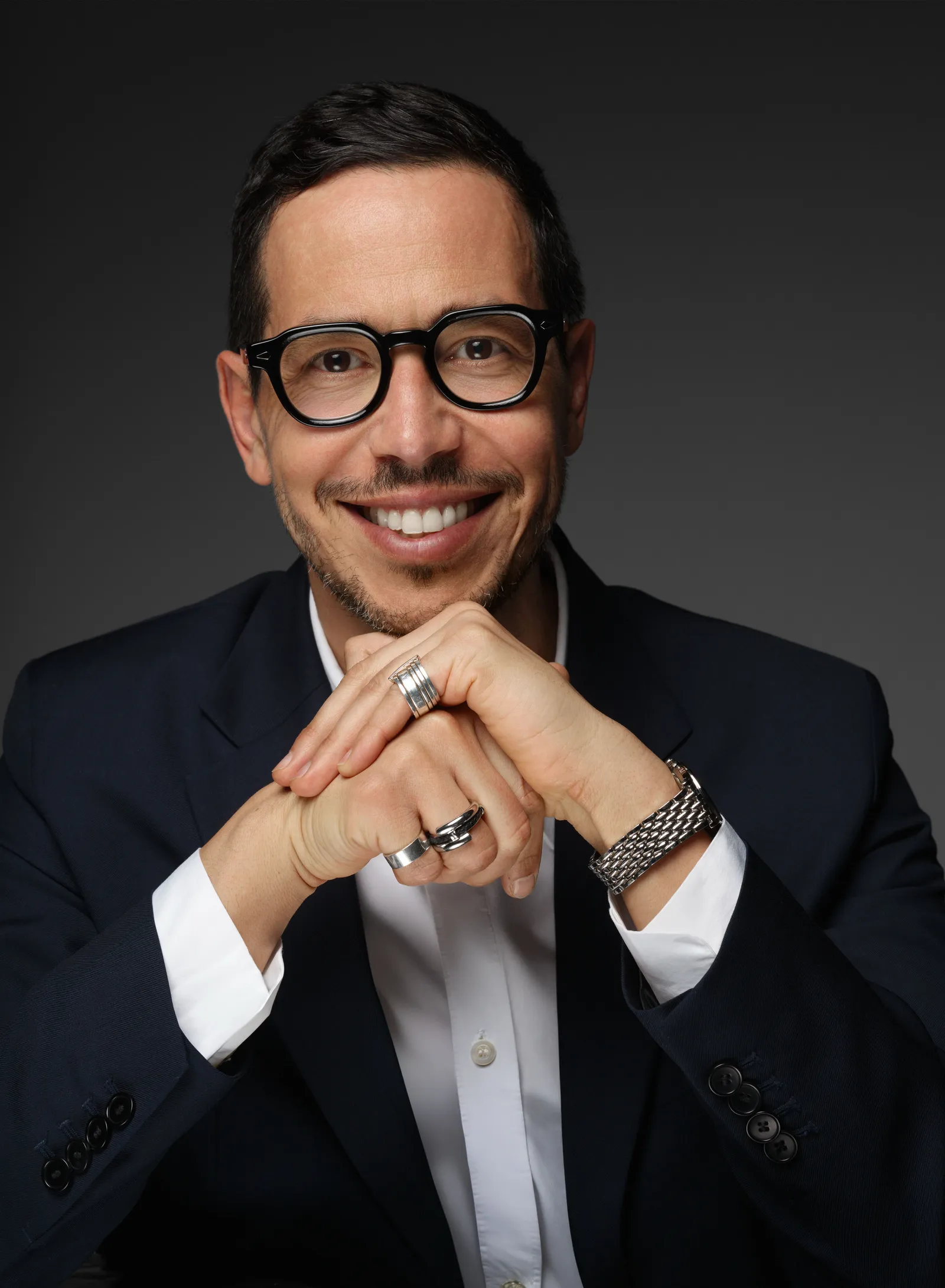 Image may contain Blazer Clothing Coat Jacket Face Happy Head Person Smile Formal Wear Suit and Photography