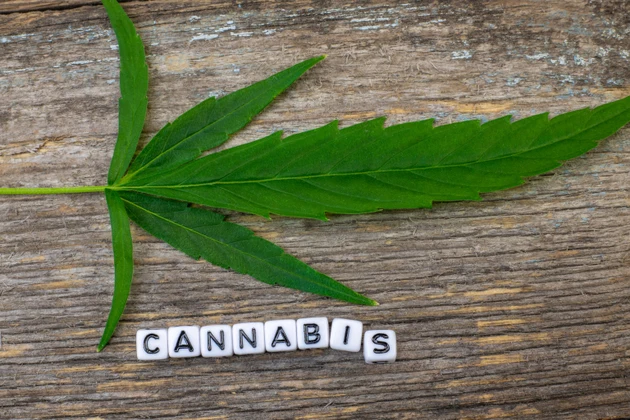 Cannabis leaf on wood with inscription text CANNABIS
