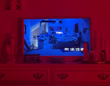 Hisense Déco TV sitting on dresser while playing a scene from "Paranormal Activity 3"