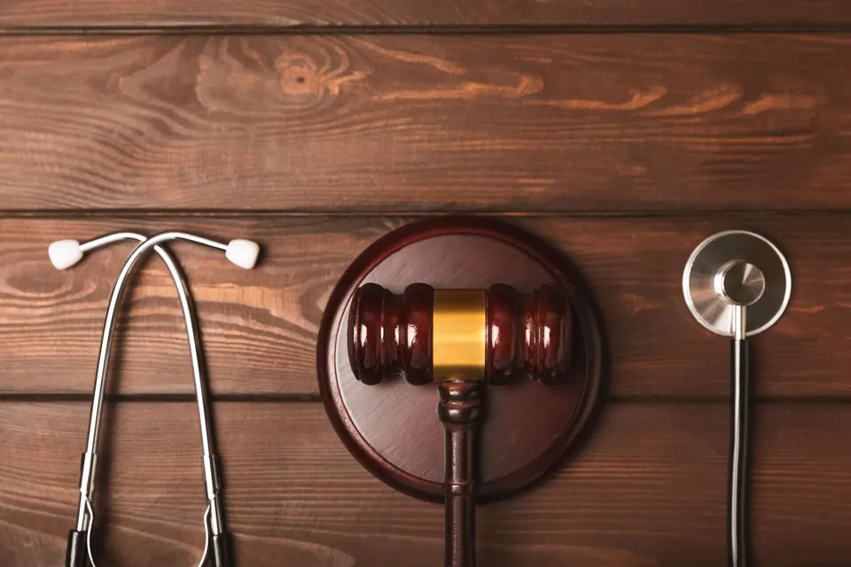 A stethoscope and hammer on a desk. Medical malpractice, personal injury lawyer, and healthcare legal aspects concept.Lawyer.Legal definition of medical negligence. Law concept.Healthcare and Medicine