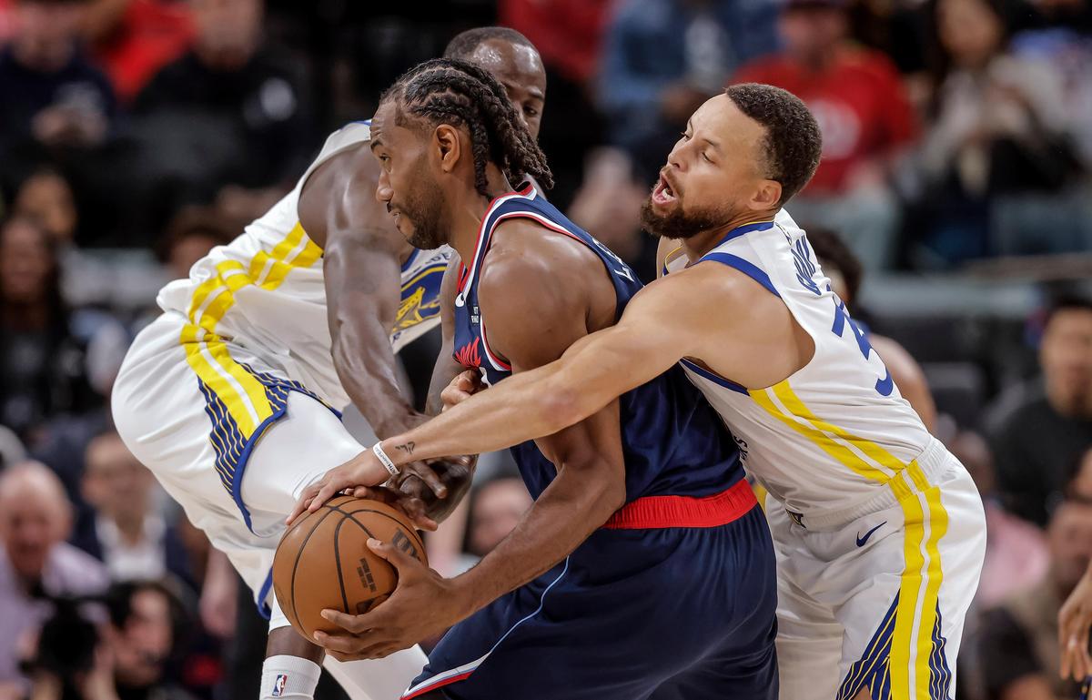 Golden State Warriors' Draymond Green, left, and Stephen Curry (30) defend against Los Angeles Clippers' Kawhi Leonard in the first half of an NBA play-in game. Golden State Warriors' Draymond Green, left, and Stephen Curry (30) defend against Los Angeles Clippers' Kawhi Leonard in the first half of an NBA play-in game.