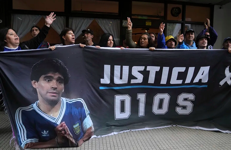 Hinchas de Maradona muestran una pancarta a las afueras del tribunal en marzo de 2025, en Buenos Aires, Argentina.