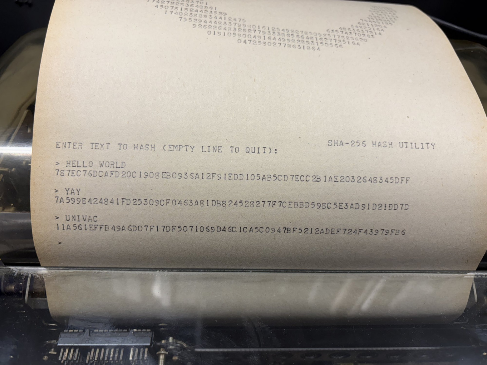 Утилита SHA-256, хэширующая три блока входящих данных (HELLO WORLD, YAY, UNIVAC). Teletype paper showing the SHA-256 utility hashing three inputs.