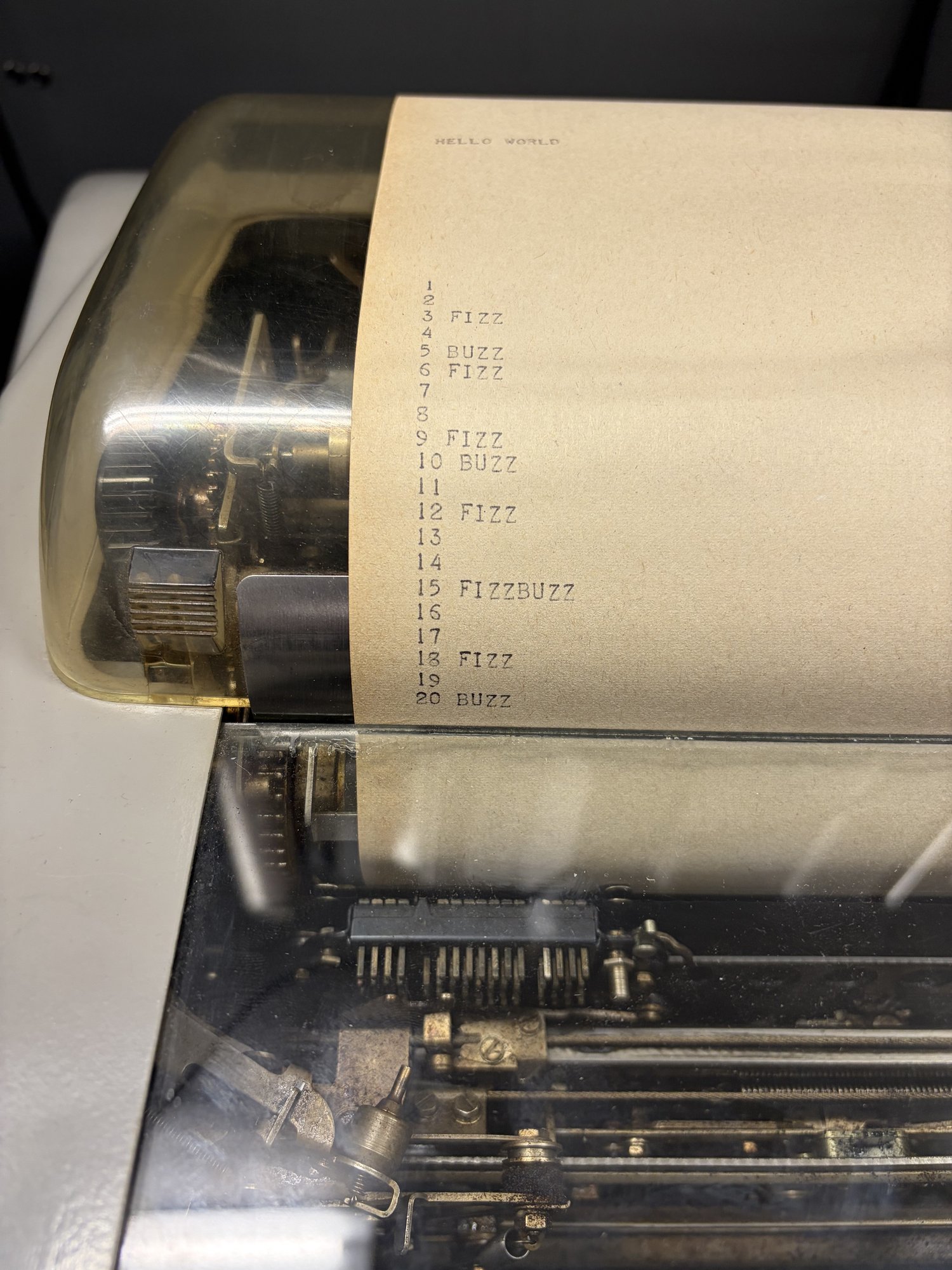 Hello world и fizzbuzz стали первыми программами на C, которые заработали на UNIVAC. Teletype paper showing HELLO WORLD followed by fizzbuzz output.