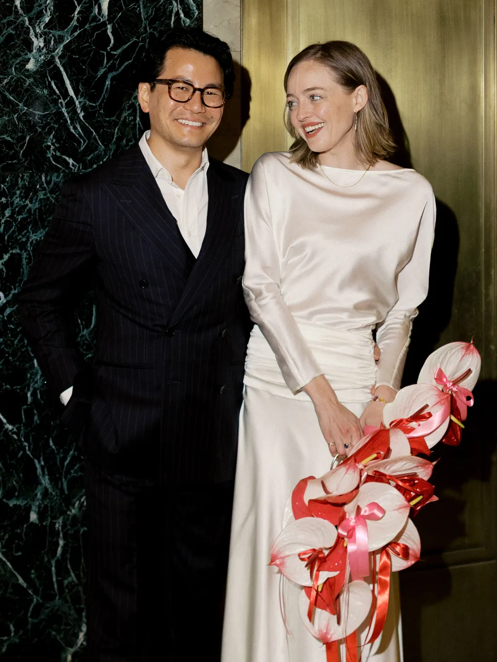 Image may contain Blazer Clothing Coat Jacket Dress Adult Person Formal Wear Suit Fashion Gown and Flower
