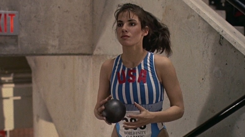 Sandra Bullock, as Kate Mason, holding an iron ball while wearing a USA uniform at World Unity Games