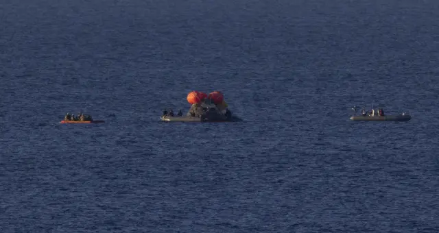 Lols equipos de rescate se acercan a por los tripulantes de la nave Orion tras amerizar en el Pacífico. En la imagen se ve el porche por el que sacará a la tripulación.