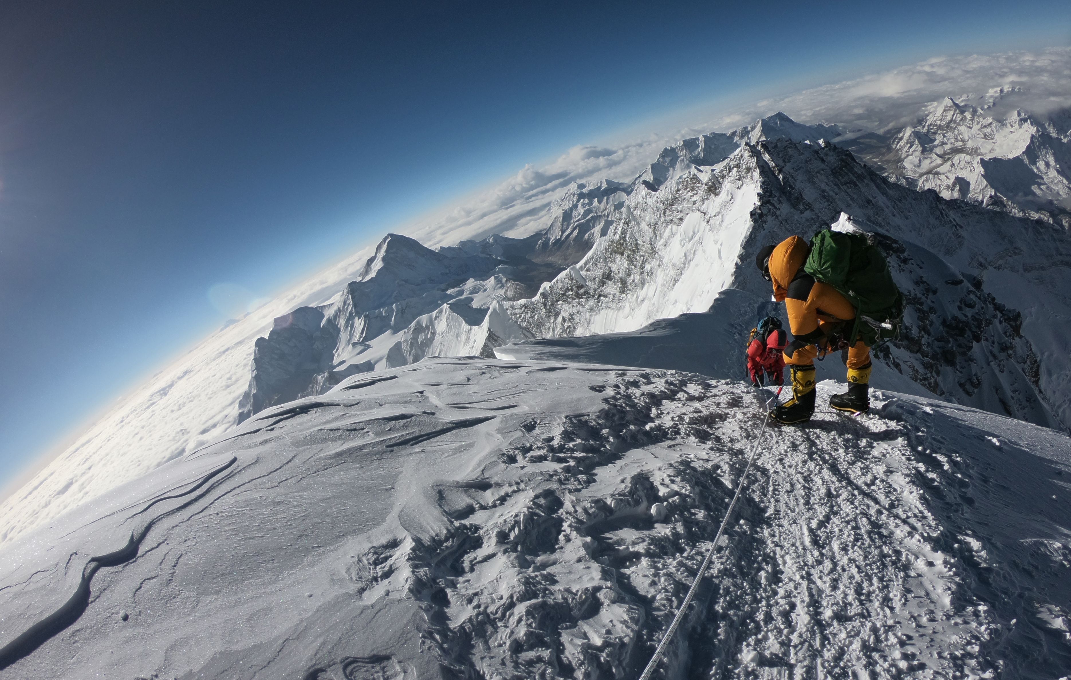 Hikers climb the summit of Mount Everest.
