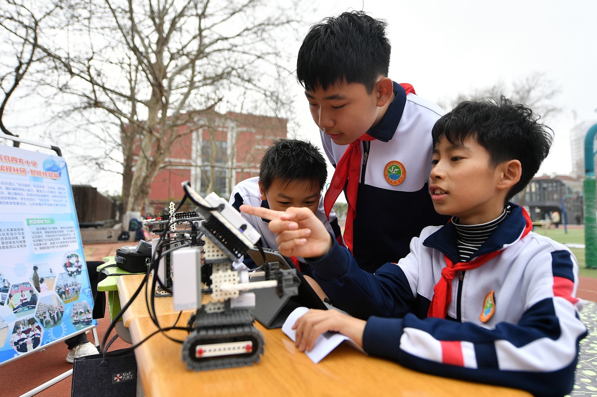 Tres ni�os chinos prueban robots en la escuela de primaria Sifang en Qingdao, en el extremo oeste del pa�s.