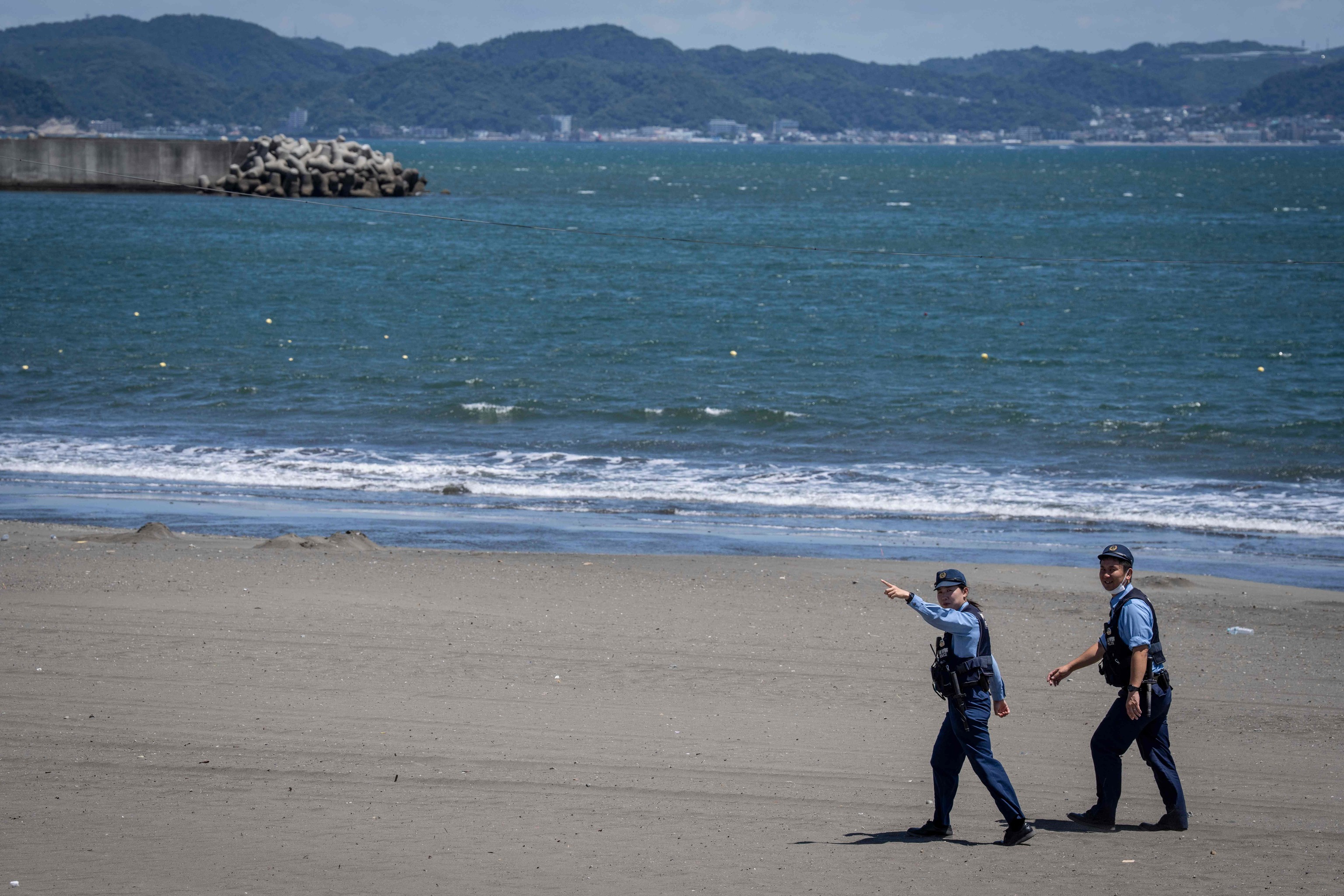 Dos polic�as vigilan una playa de Jap�n tras una alerta de tsunami.