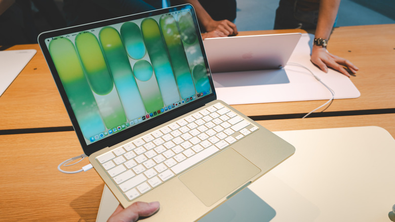 A group of customers explore and test the features of the new MacBook Neo at Apple Store.