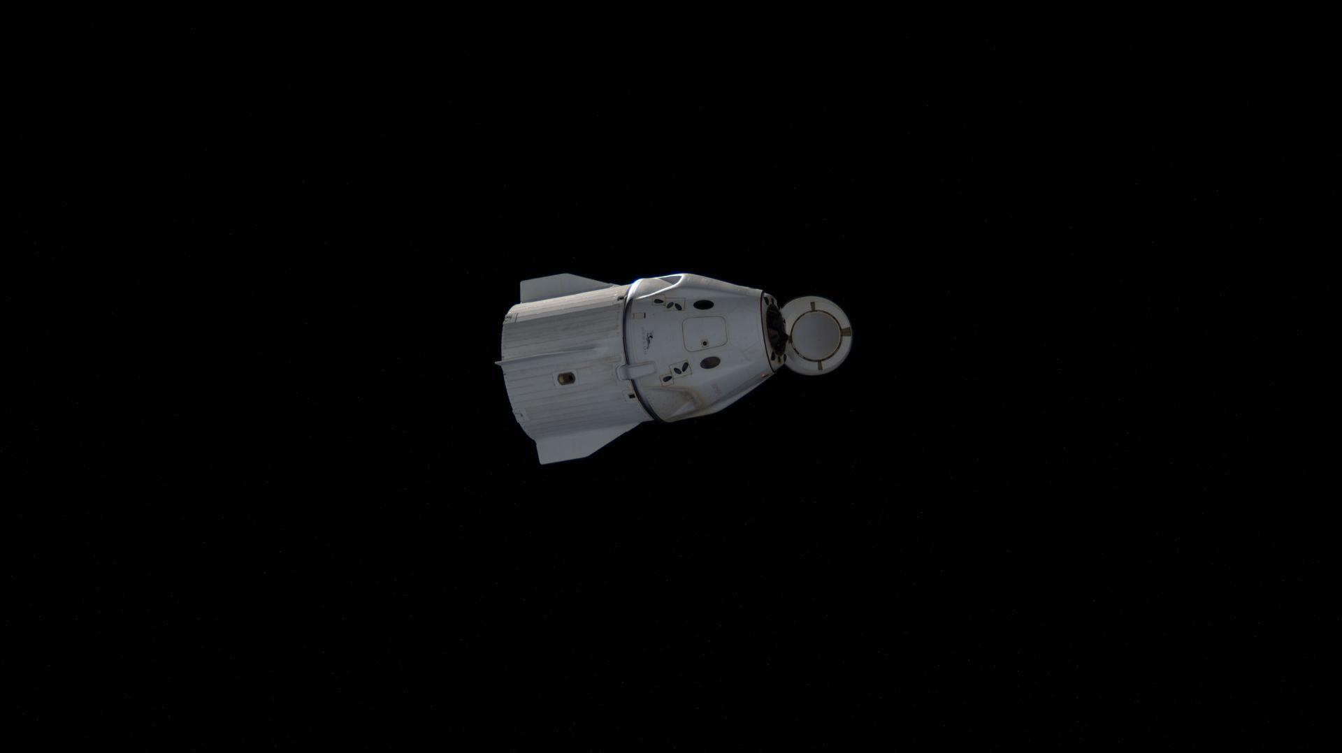 The SpaceX Dragon crew spacecraft, with its nosecone open, departs the vicinity of the International Space Station after undocking earlier from the Harmony module's space-facing port. Inside Dragon is Crew-11 Commander Zena Cardman and Pilot Mike Fincke, both NASA astronauts, with Mission Specialists Kimiya Yui of JAXA (Japan Aerospace Exploration Agency) and Oleg Platonov of Roscosmos.