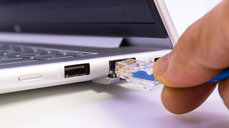 Close-up of Ethernet cable being plugged into laptop