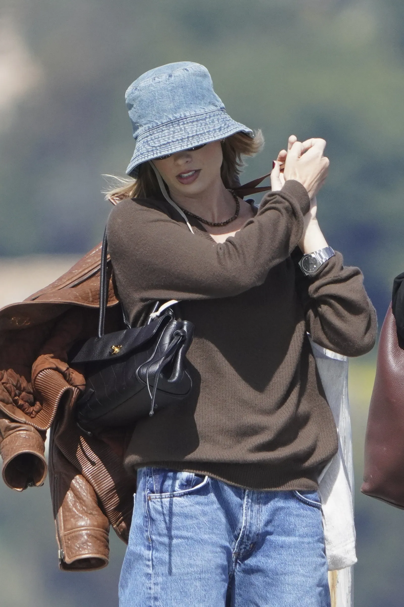 Image may contain E40 Clothing Hat Accessories Bag Handbag Coat Jacket Pants Cap Jewelry Necklace and Adult
