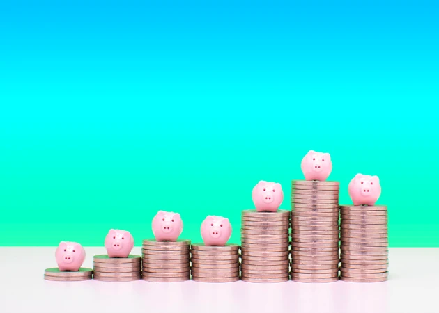 Savings concept - Piggy banks on stacks of coins