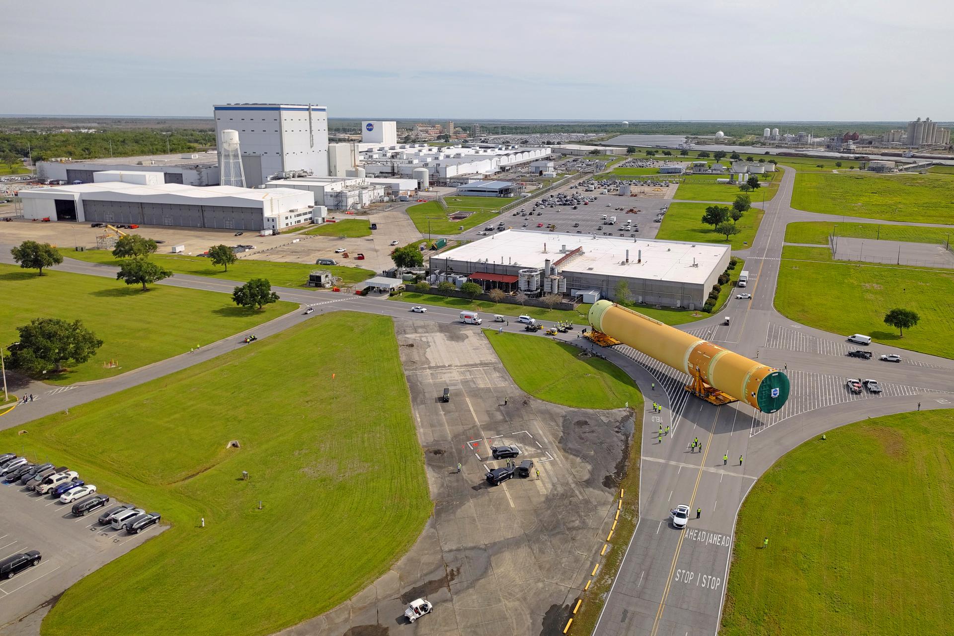 NASA moved the core stage, or the largest section, of the SLS (Space Launch System) rocket that will launch the crewed Artemis III mission in 2027 from the agency’s Michoud Assembly Facility to the agency’s Pegasus barge in New Orleans on April 20. The barge will ferry the top four-fifths – the section containing the liquid hydrogen tank, liquid oxygen tank, intertank, and forward skirt – of the SLS core stage to NASA’s Kennedy Space Center in Florida to complete outfitting and vertical integration.  Teams with NASA and Boeing, the SLS core stage lead contractor, used specialized transporters to guide the top four-fifths from the NASA rocket factory to Pegasus. Prior to the move, technicians added an engine section transportation simulator to the rocket stage for shipment to the Space Coast.  Next year’s Artemis III mission will launch astronauts to Earth’s orbit aboard the Orion spacecraft on top of SLS to test rendezvous and docking capabilities between Orion and commercial spacecraft needed to land Artemis IV astronauts on the Moon in 2028. NASA’s SLS is the only rocket capable of sending Orion, astronauts, and supplies to the Moon in a single launch.  