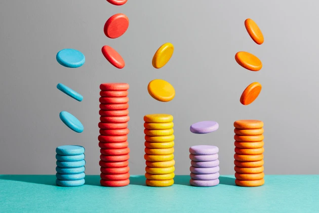 Five stacks of coloured coins arranged as a bar chart
