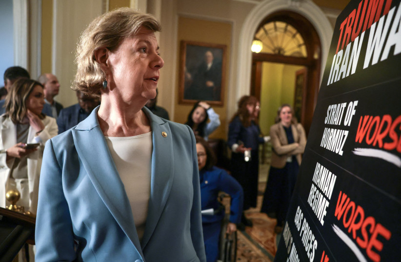 US Senator Tammy Baldwin (D-WI) looks a a sign about the war in Iran ahead of a press conference following the Democrats weekly policy lunch on Capitol Hill in Washington, DC, US, April 14, 2026.
