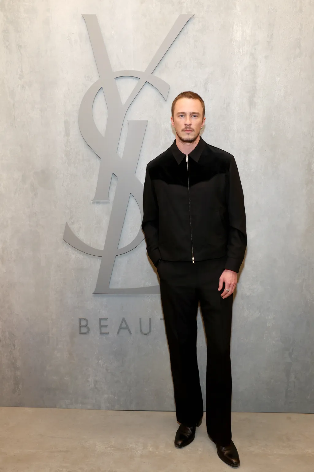 Image may contain Clothing Formal Wear Suit Coat Jacket Face Head Person Photography Portrait Standing and Adult