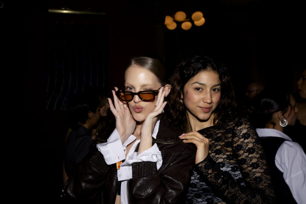 two women looking at a camera in a dark room